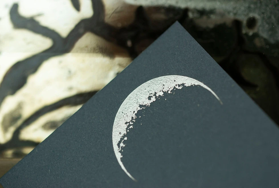 croissant de lune argent sur papier bleu gris