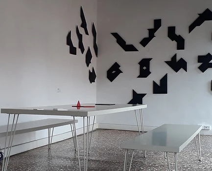 pièce blanche avec formes noires au mur