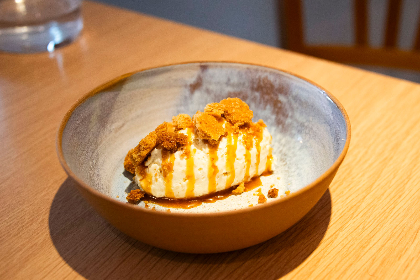 assiette avec quenelle de riz au lait et biscuits, coulis de caramel