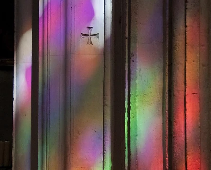 reflets de vitraux colorés sur des colonnes dans une église