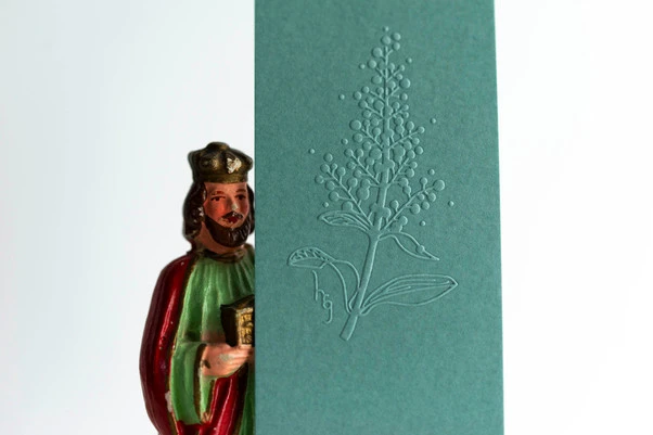 marque page papier vert et statuette roi mage gros plan